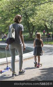 Mother and daughter with push scooter in Central Park, Manhattan, New York City, New York State, USA