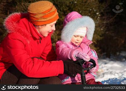Mother and daughter with snow scooter