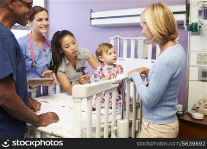 Mother And Daughter With Staff In Pediatric Ward Of Hospital