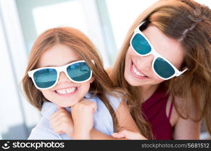 Mother and daughter with sunglasses and having fun