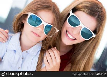 Mother and daughter with sunglasses and having fun