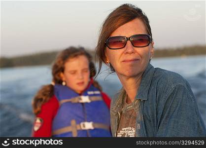 Mother and daughter with the sunlight in their face while riding in a boat at Lake of the Woods, Ontario