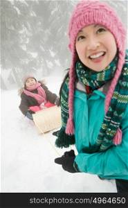 Mother and daughter with toboggan