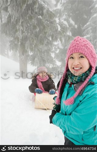 Mother and daughter with toboggan