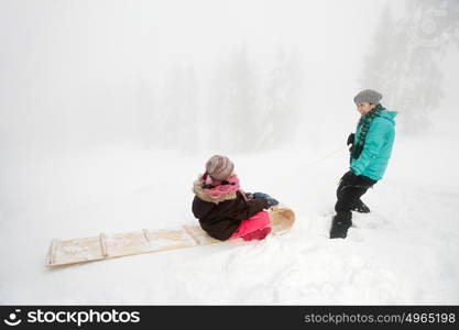 Mother and daughter with toboggan