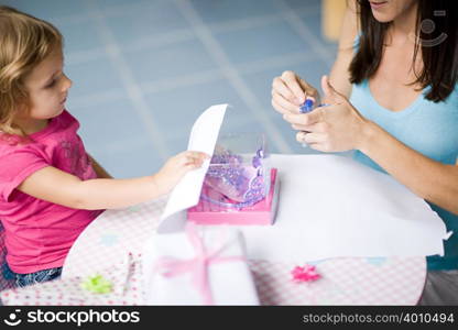 Mother and daughter wrapping gift