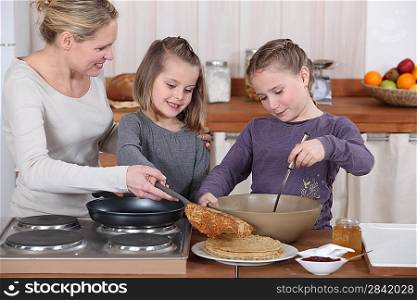 Mother and daughters making pancakes