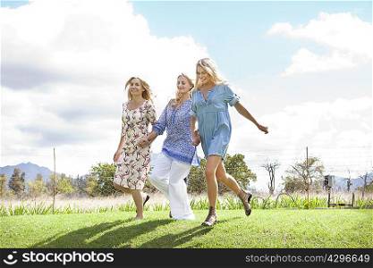 Mother and daughters running in garden