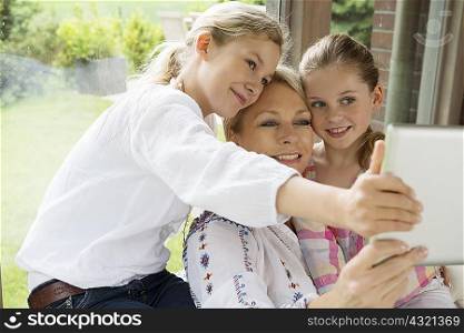 Mother and daughters using digital tablet