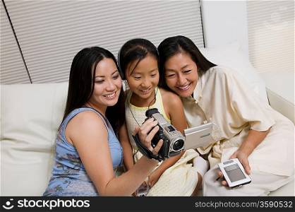 Mother and Daughters with Video Camera and PDA