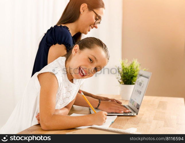 Mother and daugther at home doing homework together