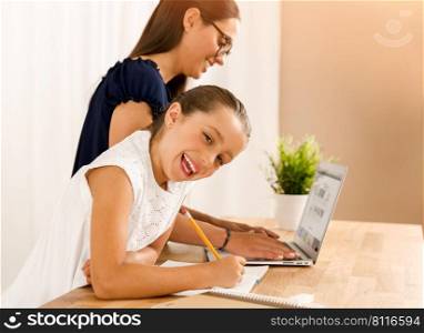 Mother and daugther at home doing homework together