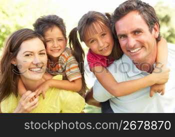 Mother And Father Giving Children Piggy Back