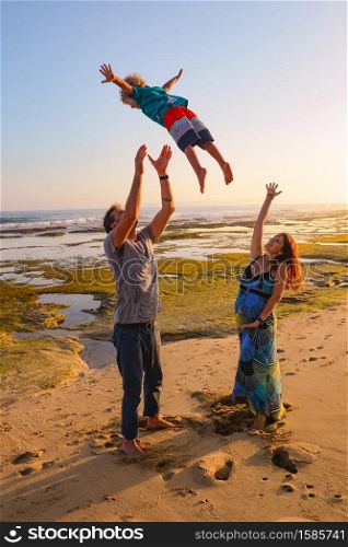 Mother and father throwing a child in the air