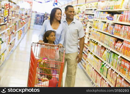 Mother and father with young daughter shopping at the grocery store.