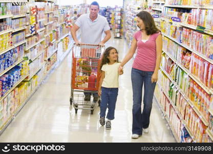 Mother and father with young daughter shopping for a new car