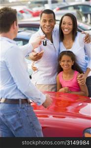 Mother and father with young daughter shopping for a new car