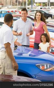 Mother and father with young daughter shopping for a new car