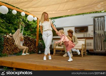 Mother and gaughter having fun at the trailer, summer camping. Family with kids travel in camp car, nature and forest on background. Campsite adventure, travelling lifestyle, campers. Mother and gaughter having fun at trailer, campers