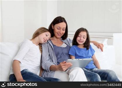 Mother and girls using electronic tablet at home