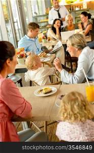 Mother and grandmother with children at cafe eating cake women