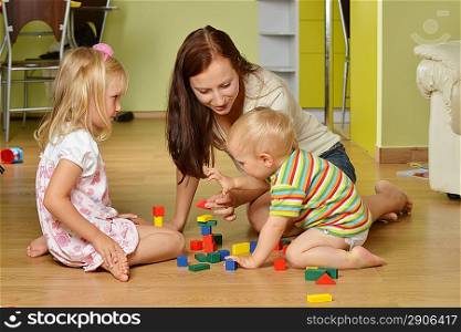 mother and her childs playing with cubes at home