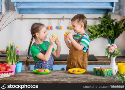Mother and her daughter painting eggs. Happy family preparing for Easter. Cute little child girl wearing bunny ears.. Happy family preparing for Easter