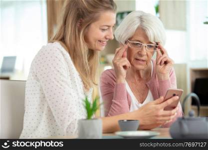 mother and her daughter watching pictures on a phone screen
