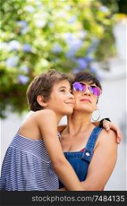 Mother and her little daughter traveling together in urban background. Women wearing sunglasses.. Mother and her little daughter traveling together in urban background.