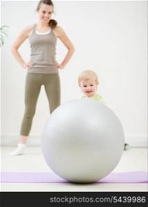 Mother and kid playing with fitness ball