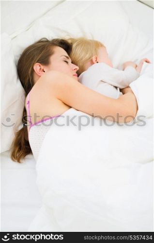 Mother and kid sleeping together in bed