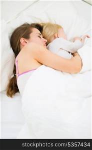 Mother and kid sleeping together in bed