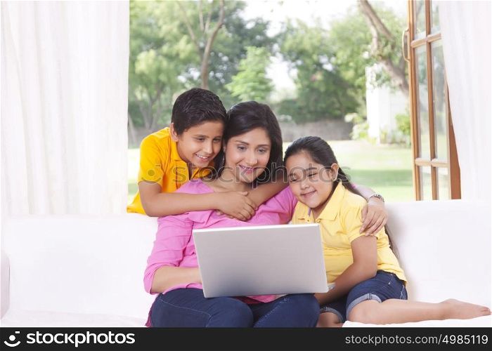Mother and kids looking at laptop
