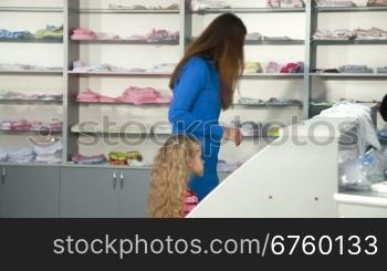 Mother and little daughter shopping for girls clothes in a clothing store, looking underwear