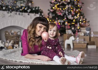 Mother and little daughter with Christmas decorations.. Christmas photo shoot mom and little daughter 9411.