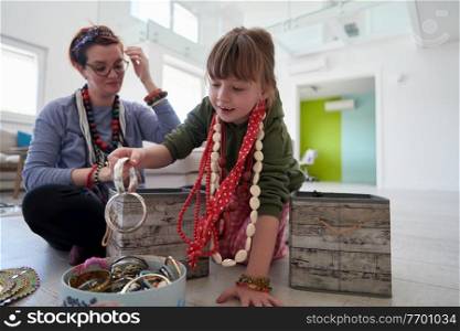 Mother and little girl daughter playing with jewelry while staying at home in coronavirus quarantine