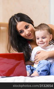 mother and son are using laptop at home