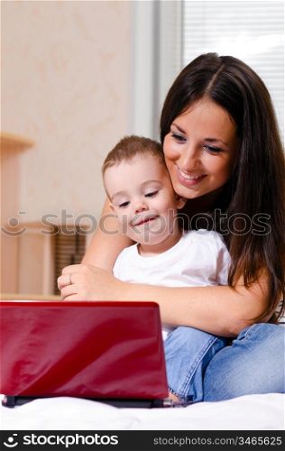 mother and son are using laptop at home