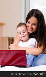 mother and son are using laptop at home