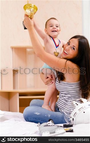 mother and son at home with golden cup