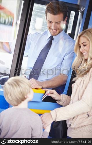 Mother And Son Boarding Bus And Using Pass