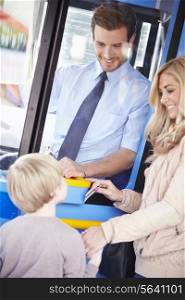 Mother And Son Boarding Bus And Using Pass
