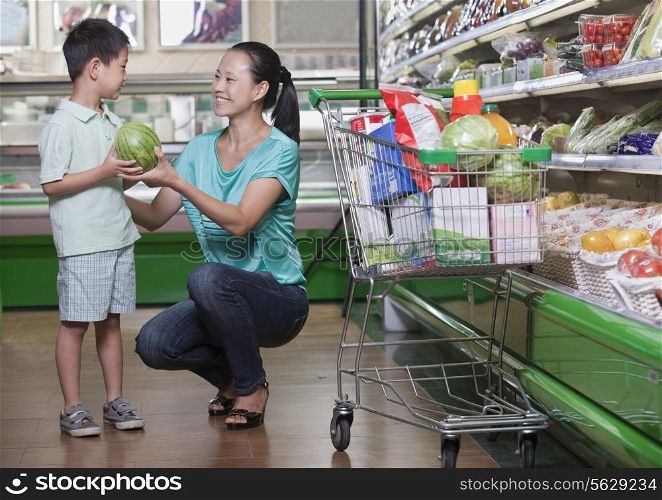 Mother and son buying watermelon in supermarket, Beijing
