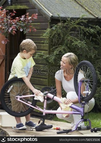 Mother And Son Cleaning Bike Together