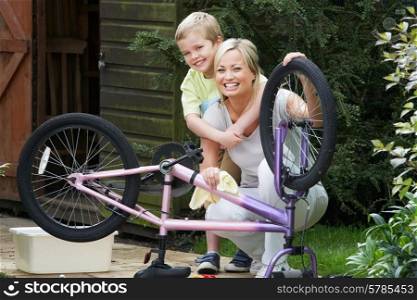 Mother And Son Cleaning Bike Together