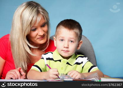 mother and son drawing together, mom helping with homework blue background