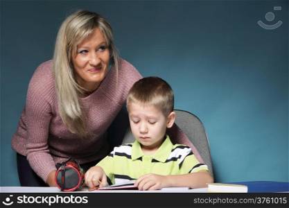 mother and son drawing together, mom helping with homework daycare blue background