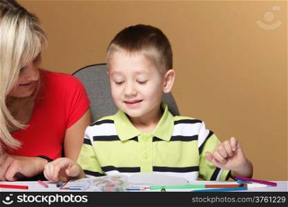 mother and son drawing together, mom helping with homework daycare brown background