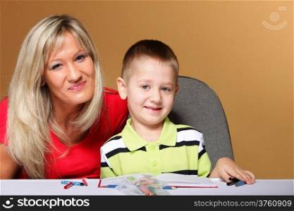 mother and son drawing together, mom helping with homework orange background