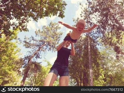 Mother and son have activities together in spring park. Happy emotion concept.